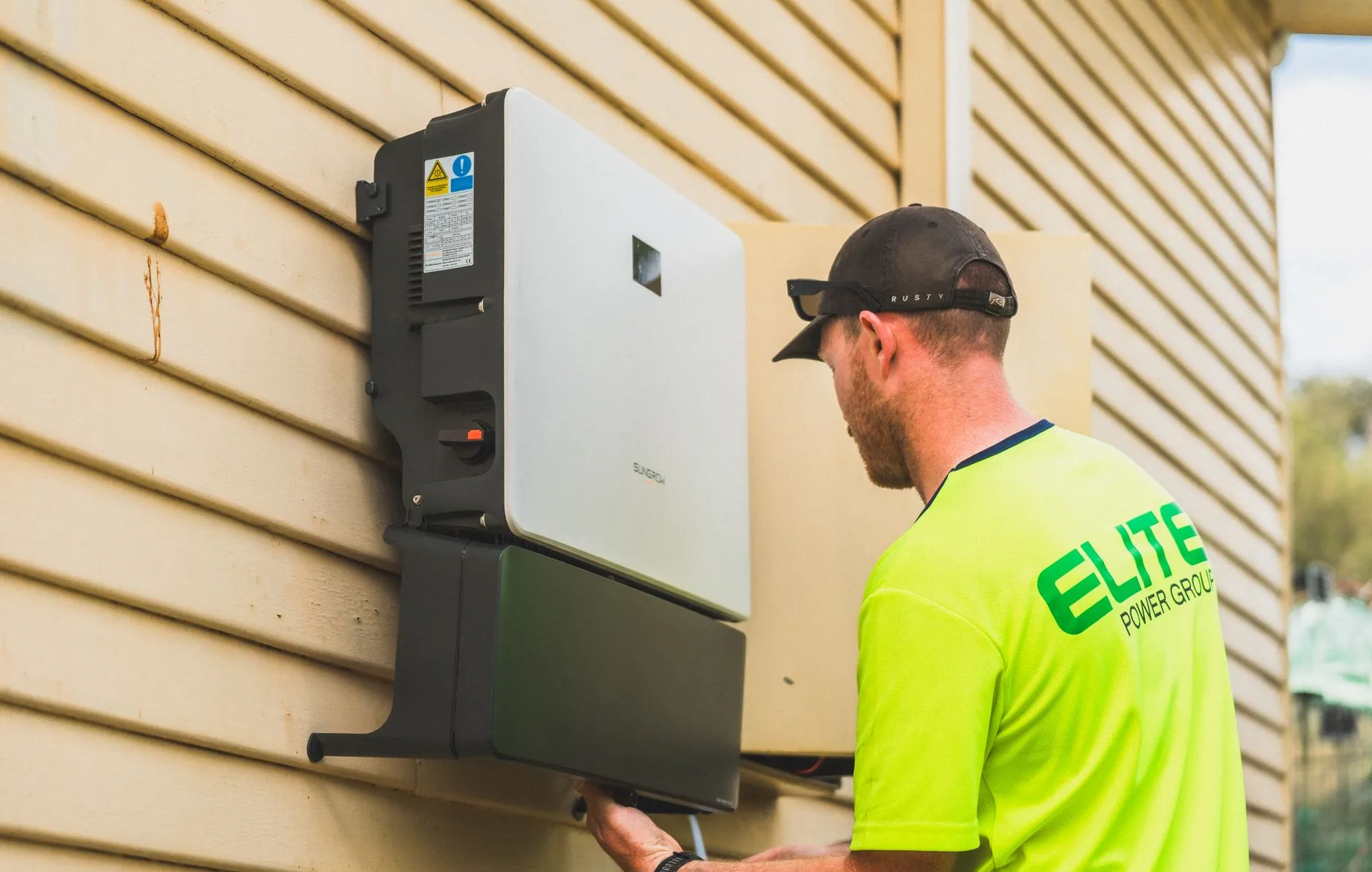 Groupe électrogène inverter portable installé à l'extérieur d'une maison, relié par un câble de puissance